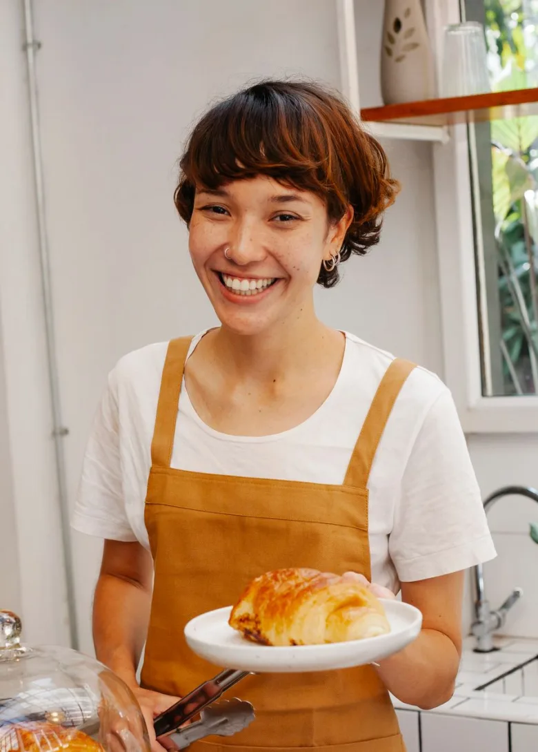 A small-business owner smiling behind her counter, proud of how her brand looks